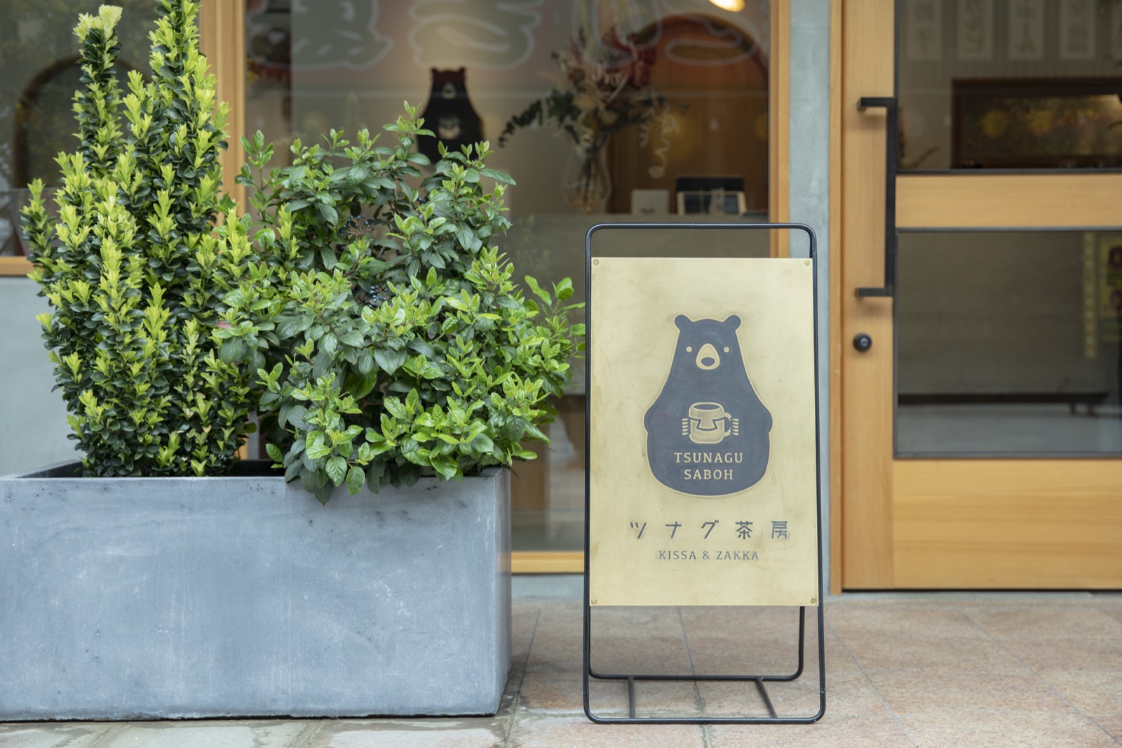 ツナグ茶房の看板と店先の植栽